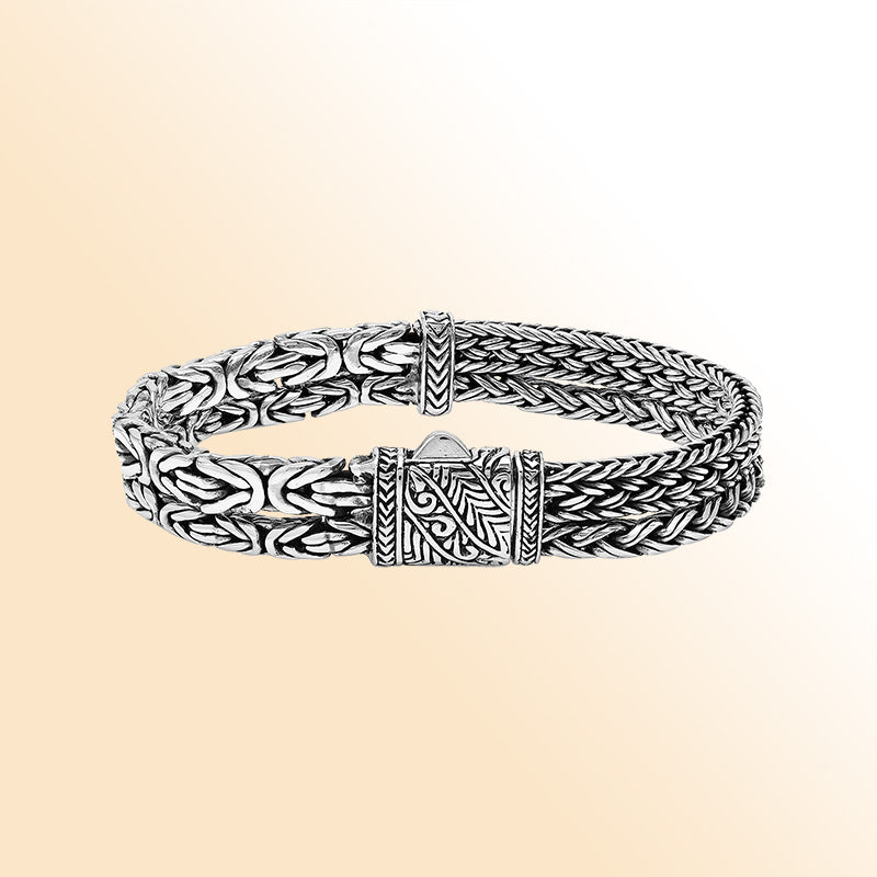 A handcrafted sterling silver woven bracelet featuring polished Balinese textures, sleek detailing, and a secure push clasp, designed for elegant everyday or statement jewelry styling.