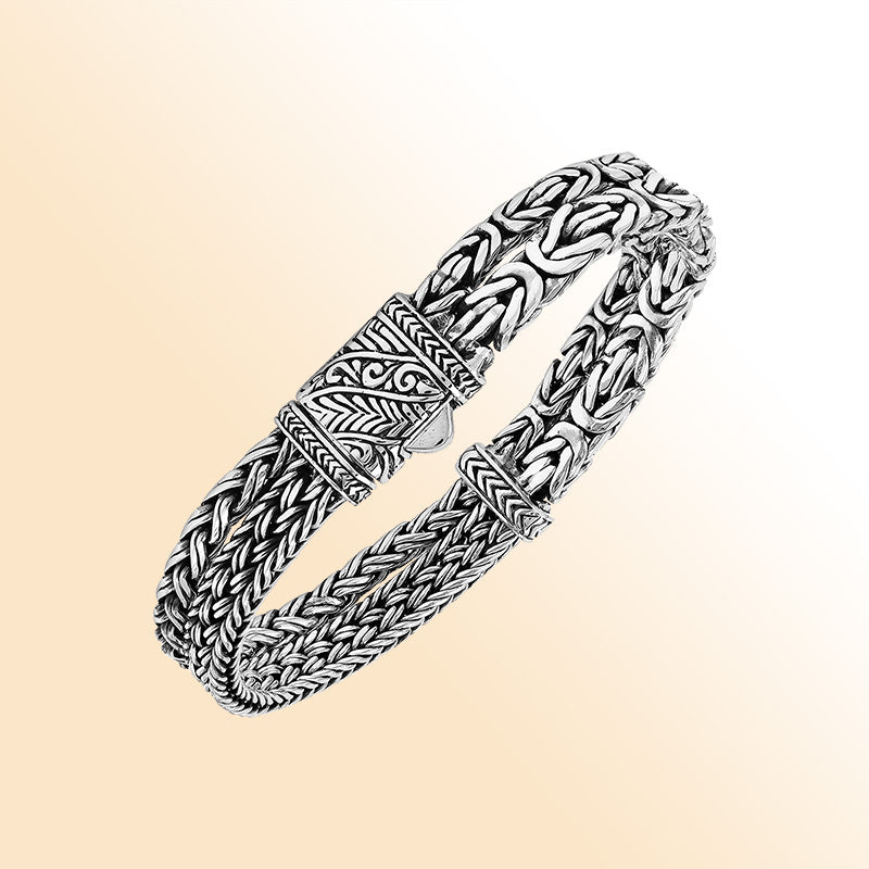 A handcrafted sterling silver woven bracelet featuring polished Balinese textures, sleek detailing, and a secure push clasp, designed for elegant everyday or statement jewelry styling.
