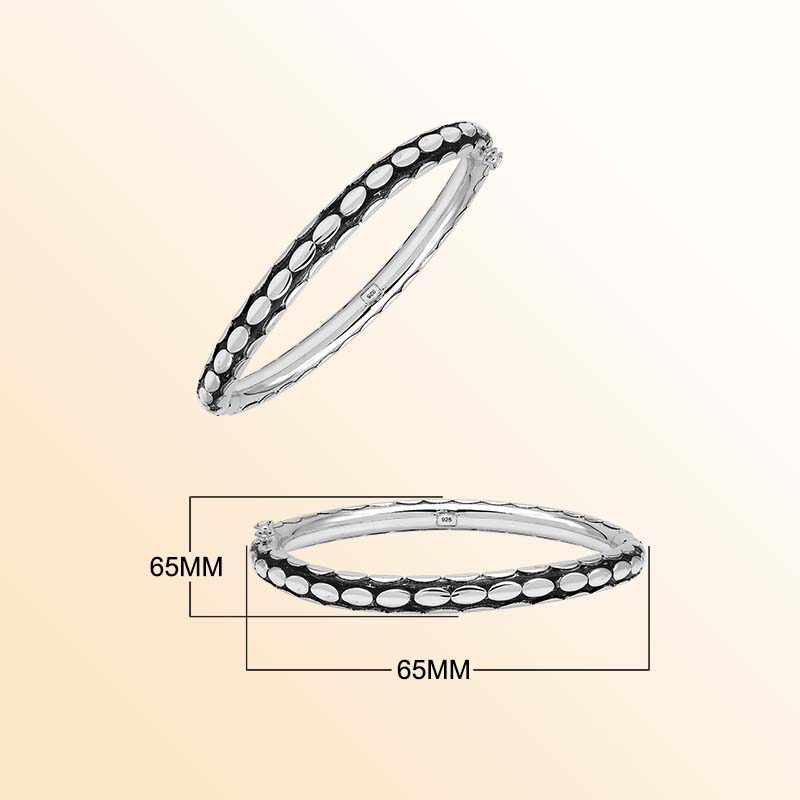 Handcrafted sterling silver medium bangle with elegant oval textured detailing, polished shine, and a secure hinge lock with safety latch for stylish daily wear.