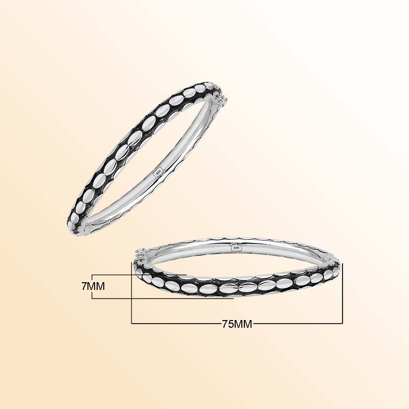 Handcrafted sterling silver medium bangle with elegant oval textured detailing, polished shine, and a secure hinge lock with safety latch for stylish daily wear.