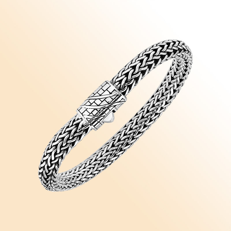 A handcrafted sterling silver wide woven bracelet featuring an engraved push clasp, polished and oxidized detailing, and bold woven styling ideal for modern everyday elegance.