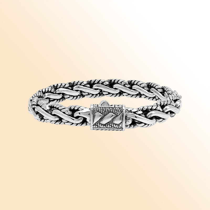 A stunning 925 sterling silver bracelet featuring a braided chain design with a decorative artistic clasp, high-gloss polished finish, and elegant Balinese craftsmanship.