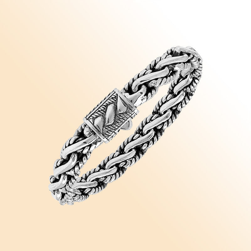 A stunning 925 sterling silver bracelet featuring a braided chain design with a decorative artistic clasp, high-gloss polished finish, and elegant Balinese craftsmanship.