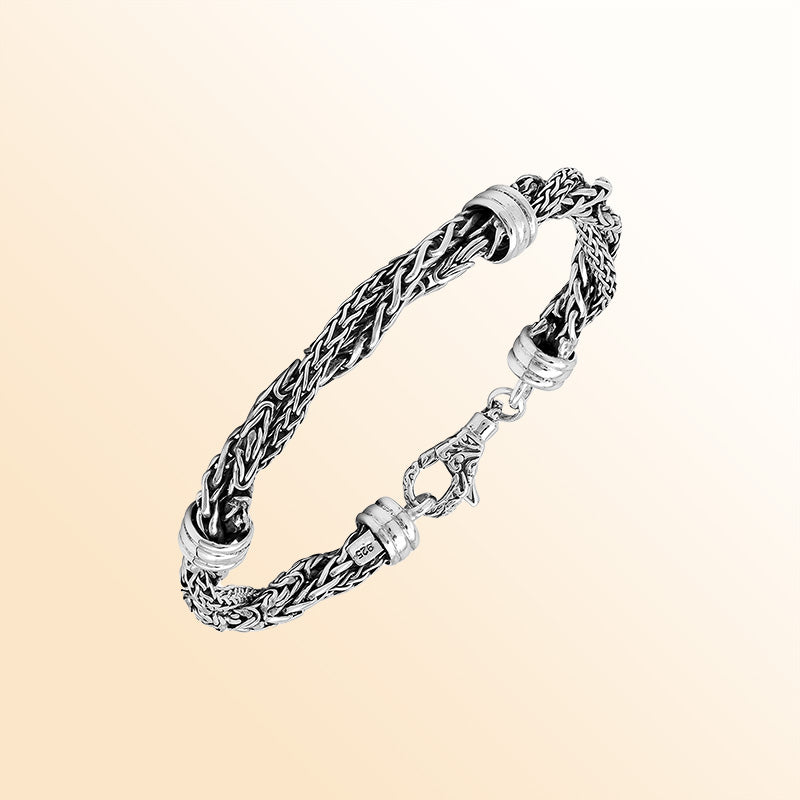 Sterling Silver bracelet with a twisted woven pattern, polished connectors, and an ornate lobster clasp, offering expressive texture, handcrafted detail, and a high-gloss finish.