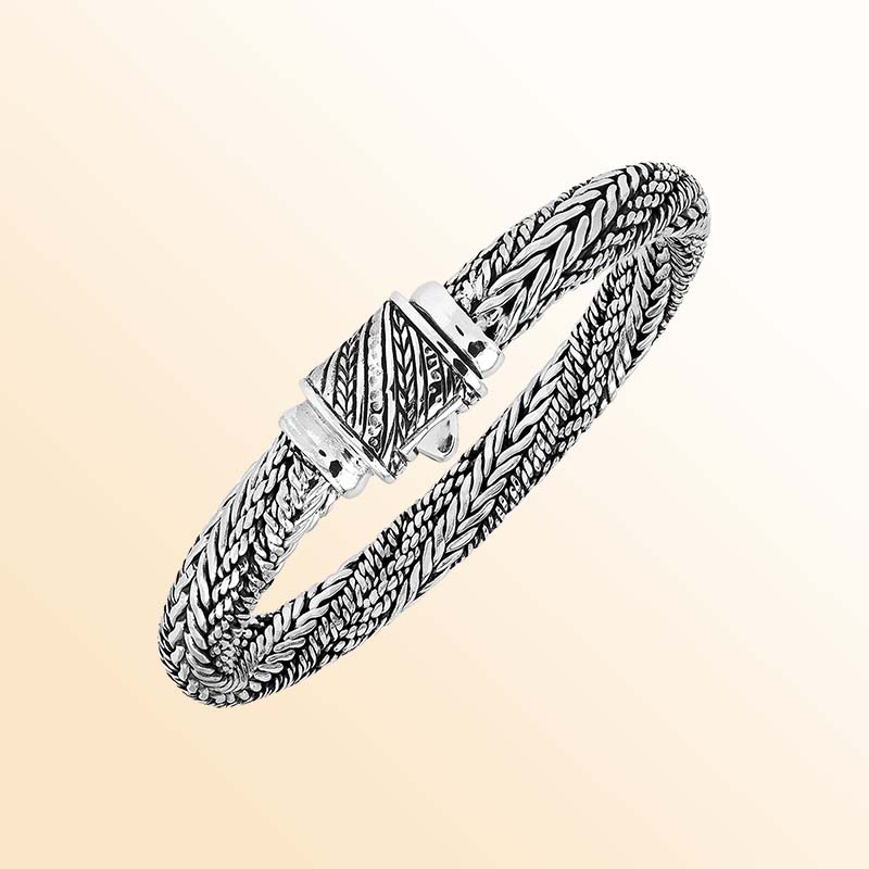 Artisan sterling silver bracelet with richly layered braided strands, detailed woven textures, contrasting oxidized accents, and an engraved decorative push clasp.