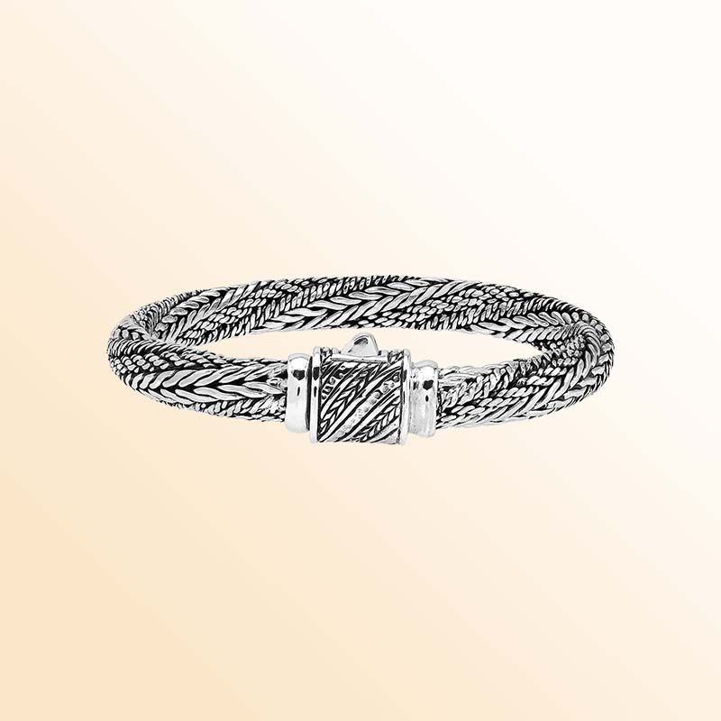 Artisan sterling silver bracelet with richly layered braided strands, detailed woven textures, contrasting oxidized accents, and an engraved decorative push clasp.