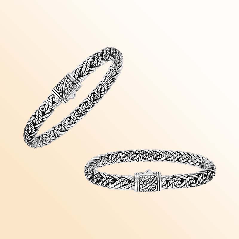 Artisan sterling silver bracelet showcasing sculptural twisted strands, wrapped rope accents, rich oxidized textures, polished highlights, and an ornate patterned push clasp.
