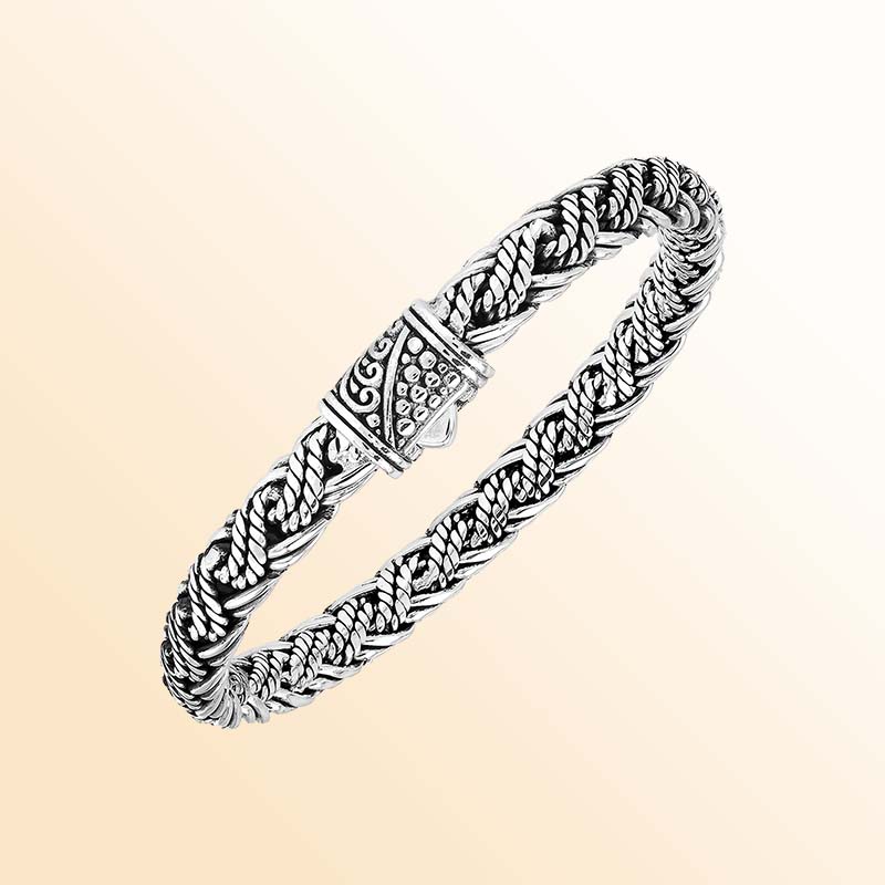 Artisan sterling silver bracelet showcasing sculptural twisted strands, wrapped rope accents, rich oxidized textures, polished highlights, and an ornate patterned push clasp.