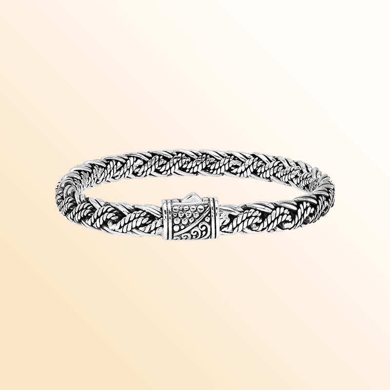 Artisan sterling silver bracelet showcasing sculptural twisted strands, wrapped rope accents, rich oxidized textures, polished highlights, and an ornate patterned push clasp.