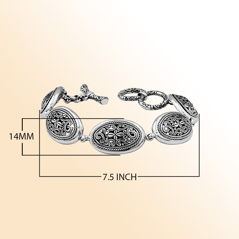 Sterling Silver oval scroll bracelet with sculpted artistic detailing, polished toggle closure, and a high-gloss shine reflecting Balinese-inspired craftsmanship and elegant styling.