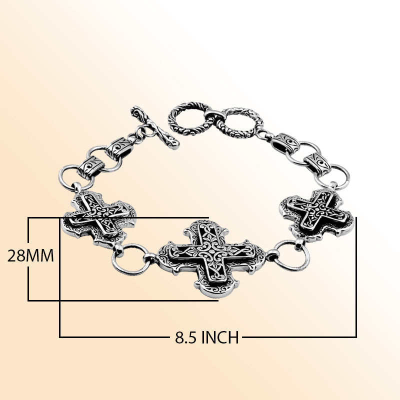 Sterling Silver artistic bracelet featuring sculpted cross-shaped panels with flowing scrollwork, polished linking rings, and a smooth toggle closure inspired by Balinese artistry.