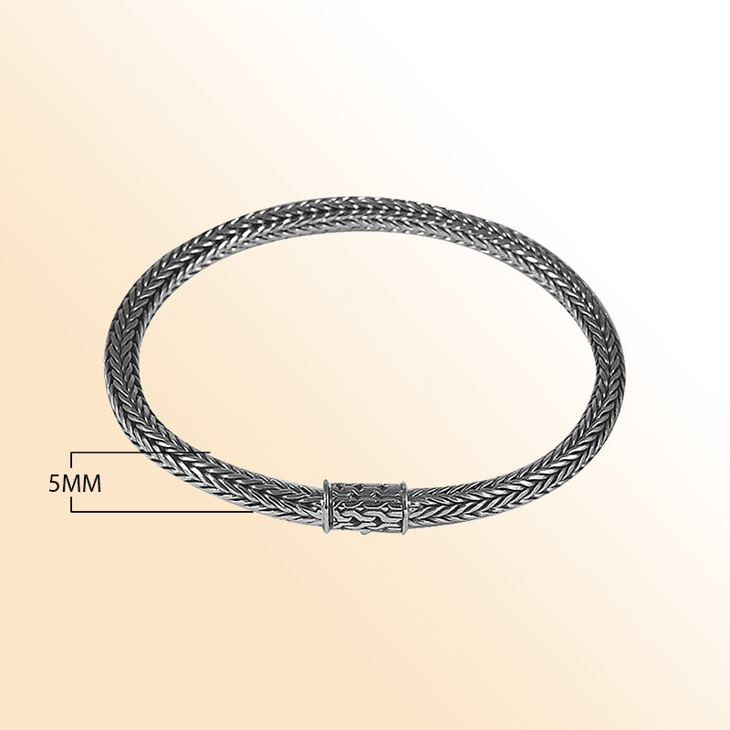 Elegant sterling silver woven bracelet featuring a polished surface, smooth chain pattern, and secure push clasp for refined everyday styling.