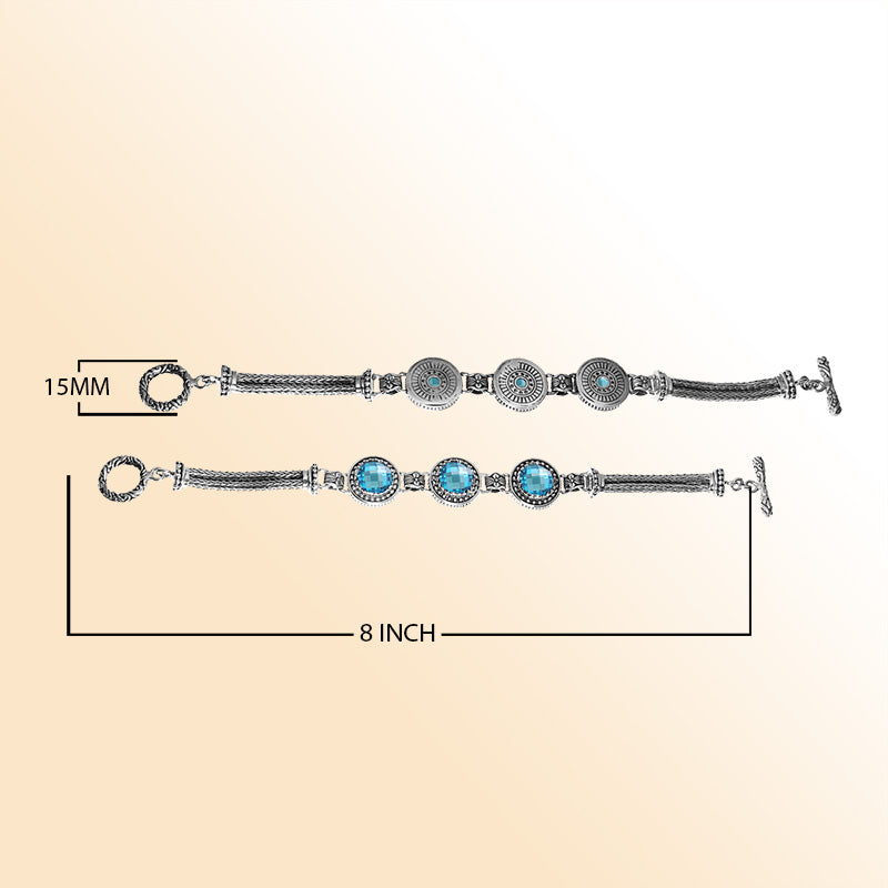 Sterling silver bracelet with faceted Blue Topaz Quartz, circular artisan motifs, braided chain work, and a decorative toggle lock.
