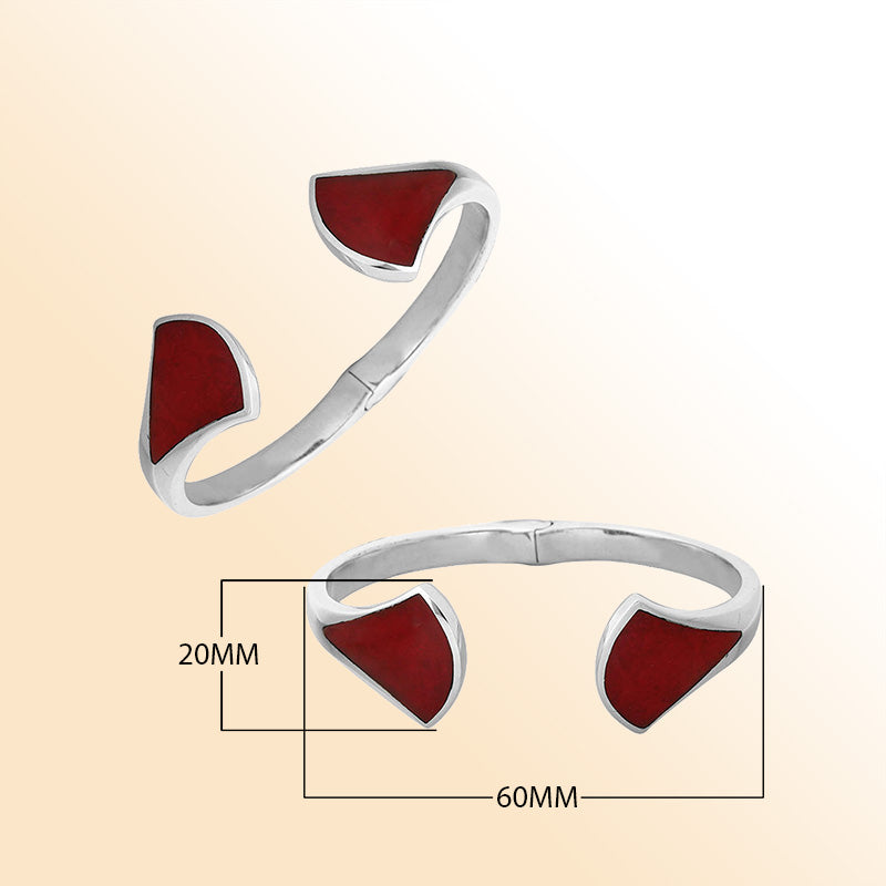 Retail sterling silver cuff showcasing vibrant Red Coral inlays on sculpted open ends with a polished finish and hinge lock for elegant daily styling.