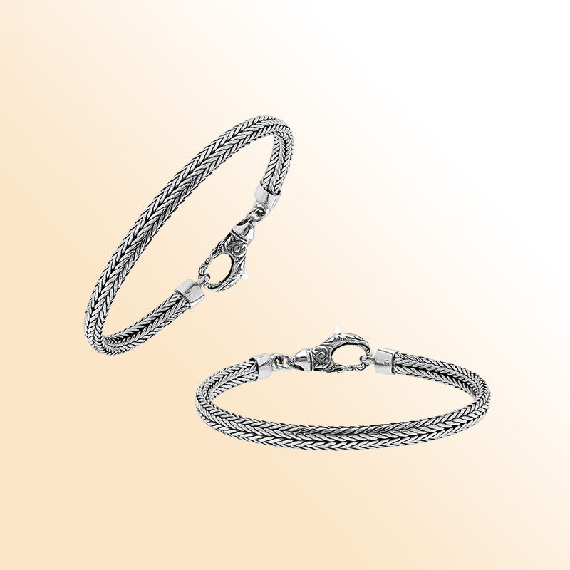 An elegant sterling silver braided chain bracelet with an artistic lobster clasp, featuring smooth texture, high-gloss polish, and intricate craftsmanship ideal for timeless modern style.