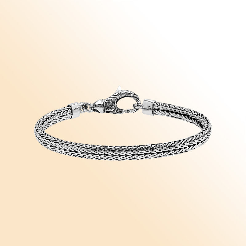 An elegant sterling silver braided chain bracelet with an artistic lobster clasp, featuring smooth texture, high-gloss polish, and intricate craftsmanship ideal for timeless modern style.