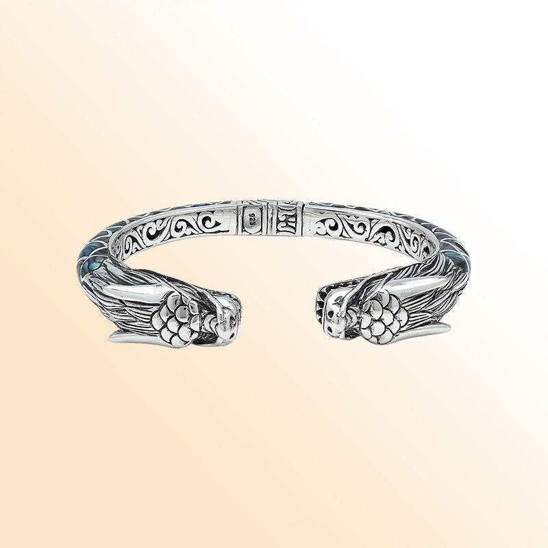 Handcrafted sterling silver phoenix bangle with Abalone Shell, featuring ornate Balinese engraving and a secure hinge lock for beauty, comfort, and everyday meaningful style.