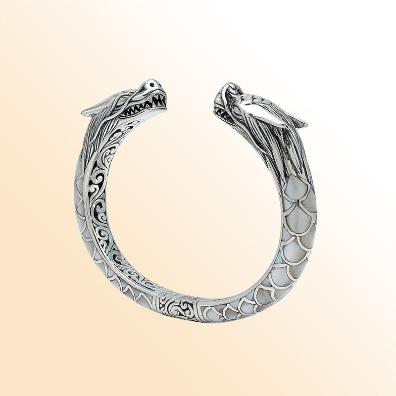 Handcrafted sterling silver phoenix guardian bangle featuring Mother of Pearl accents, ornate Balinese scroll engravings, and a secure hinge lock for a beautifully detailed, meaningful accessory.