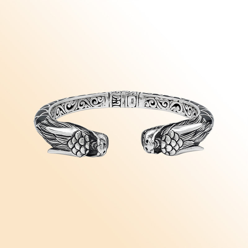 Handcrafted sterling silver phoenix guardian bangle featuring Black Shell accents, detailed Balinese scroll engravings, and a secure hinge lock for a meaningful and expressive artisan accessory.