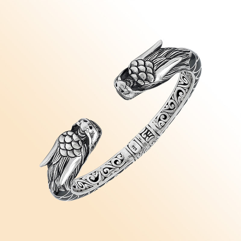 Handcrafted sterling silver phoenix guardian bangle featuring Black Shell accents, detailed Balinese scroll engravings, and a secure hinge lock for a meaningful and expressive artisan accessory.