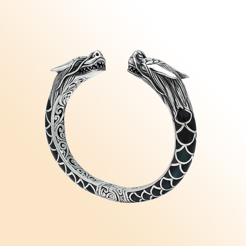 Handcrafted sterling silver phoenix guardian bangle featuring Black Shell accents, detailed Balinese scroll engravings, and a secure hinge lock for a meaningful and expressive artisan accessory.