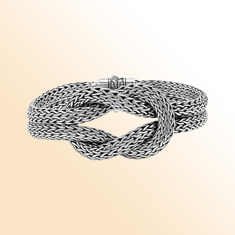 Handcrafted sterling silver woven knot bangle featuring a multi-strand Balinese chain weave design with a secure push clasp, offering symbolic beauty and bold artisan craftsmanship.