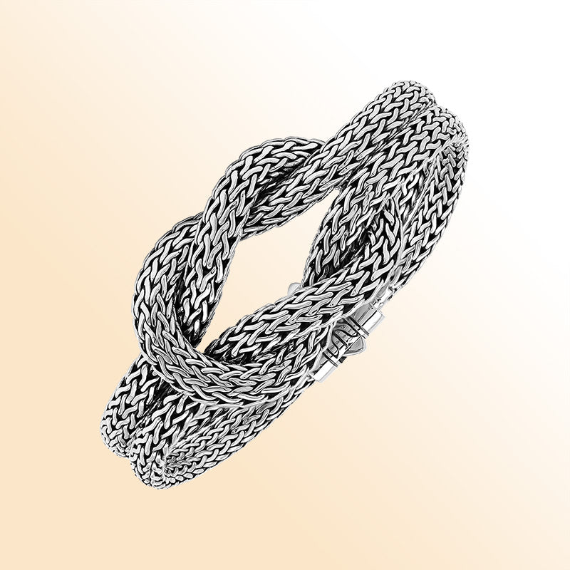 Handcrafted sterling silver woven knot bangle featuring a multi-strand Balinese chain weave design with a secure push clasp, offering symbolic beauty and bold artisan craftsmanship.