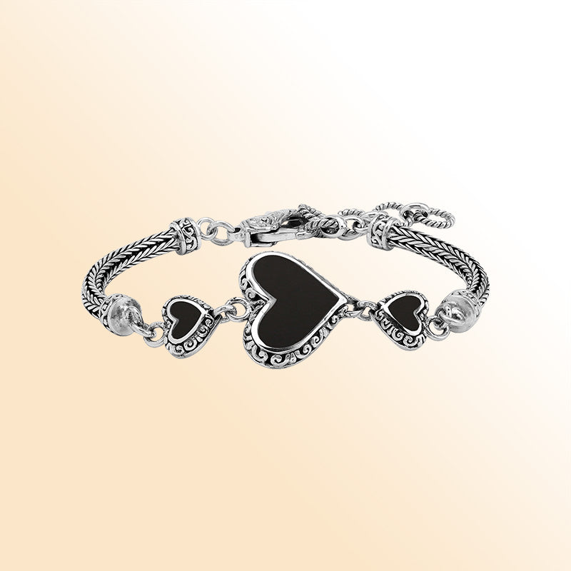 Handcrafted sterling silver bracelet featuring Black Shell heart motifs, intricate Balinese scroll engravings, and a secure lobster lock for bold, expressive, artisan-inspired everyday wear.