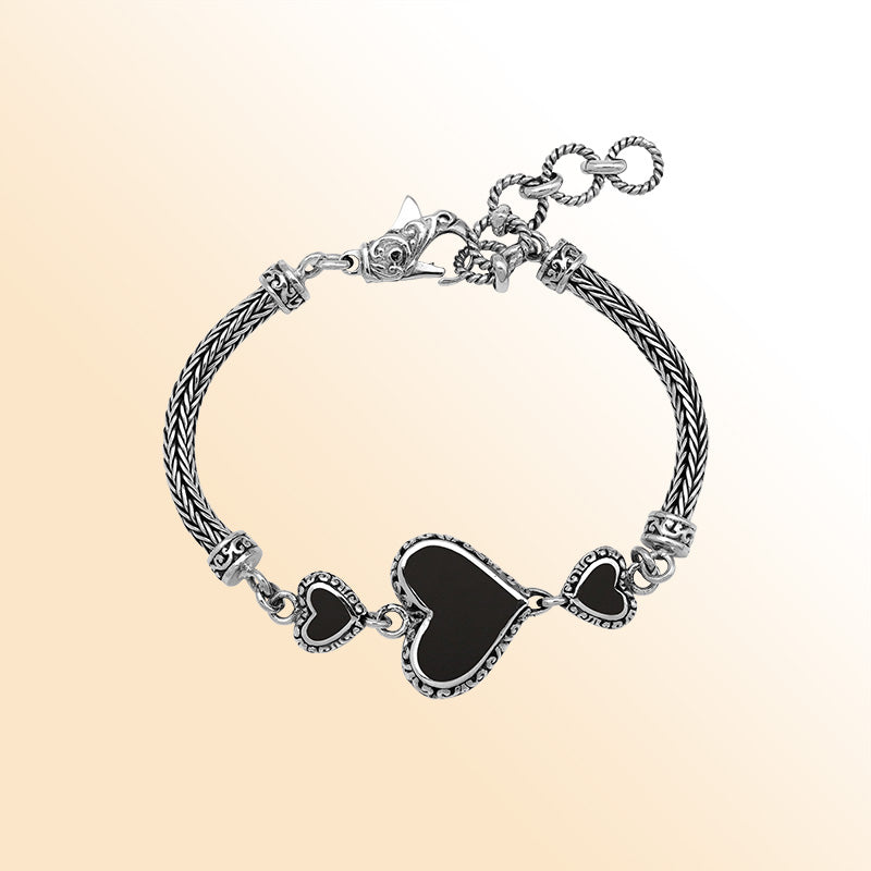 Handcrafted sterling silver bracelet featuring Black Shell heart motifs, intricate Balinese scroll engravings, and a secure lobster lock for bold, expressive, artisan-inspired everyday wear.