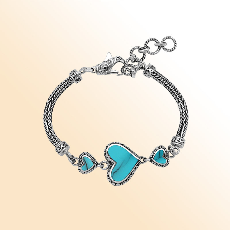 Handcrafted sterling silver bracelet featuring Turquoise Shell heart motifs, ornate Balinese scroll engravings, and a secure lobster lock for colorful, expressive, artisan-inspired everyday style.