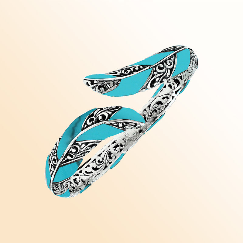 Handcrafted sterling silver feather-inspired bangle featuring vibrant Turquoise Shell inlays, intricate Balinese scroll engravings, and a secure hinge lock for colorful, expressive artisan wear.