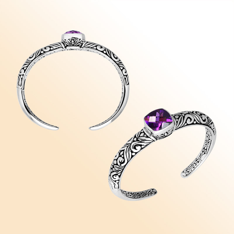 Handcrafted sterling silver bangle featuring a cushion-cut Amethyst Quartz gem, ornate Balinese scroll engravings, and a secure hinge lock for expressive artisan-inspired wear.