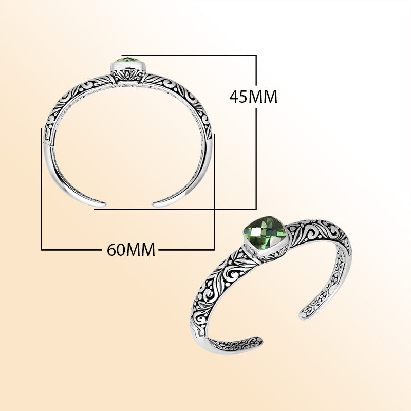 Handcrafted sterling silver bangle featuring a cushion-cut Green Amethyst Quartz gemstone, detailed Balinese scroll engravings, and a secure hinge lock for refined artisan-inspired wear.