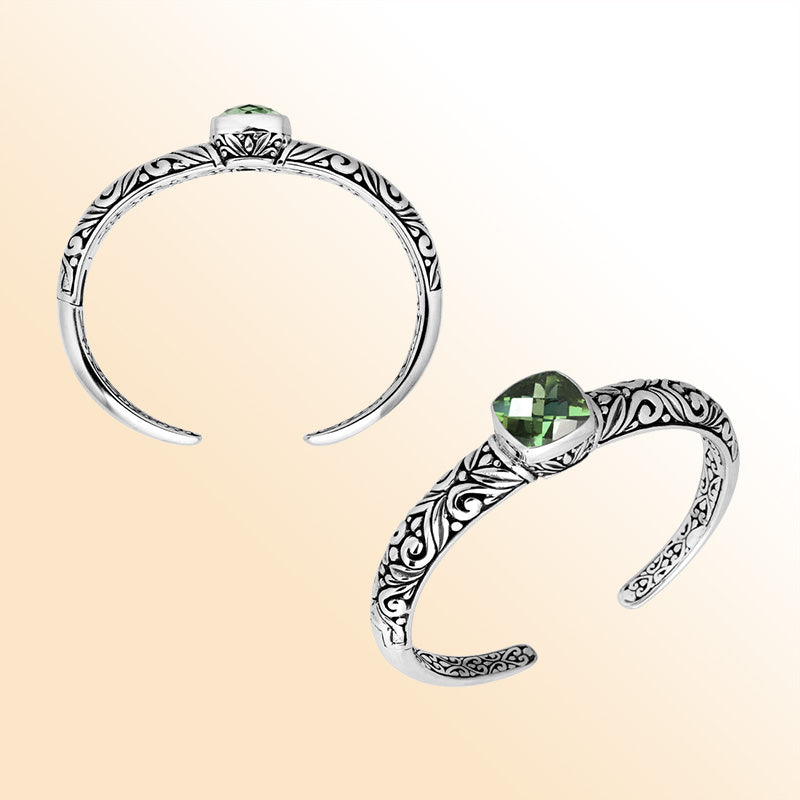 Handcrafted sterling silver bangle featuring a cushion-cut Green Amethyst Quartz gemstone, detailed Balinese scroll engravings, and a secure hinge lock for refined artisan-inspired wear.
