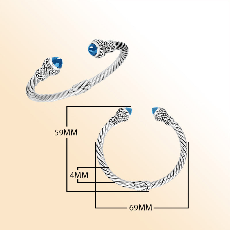 Handcrafted sterling silver cable cuff bracelet featuring sparkling faceted blue topaz quartz end caps, ornate Balinese detailing, and a secure hinge lock for daily elegance.