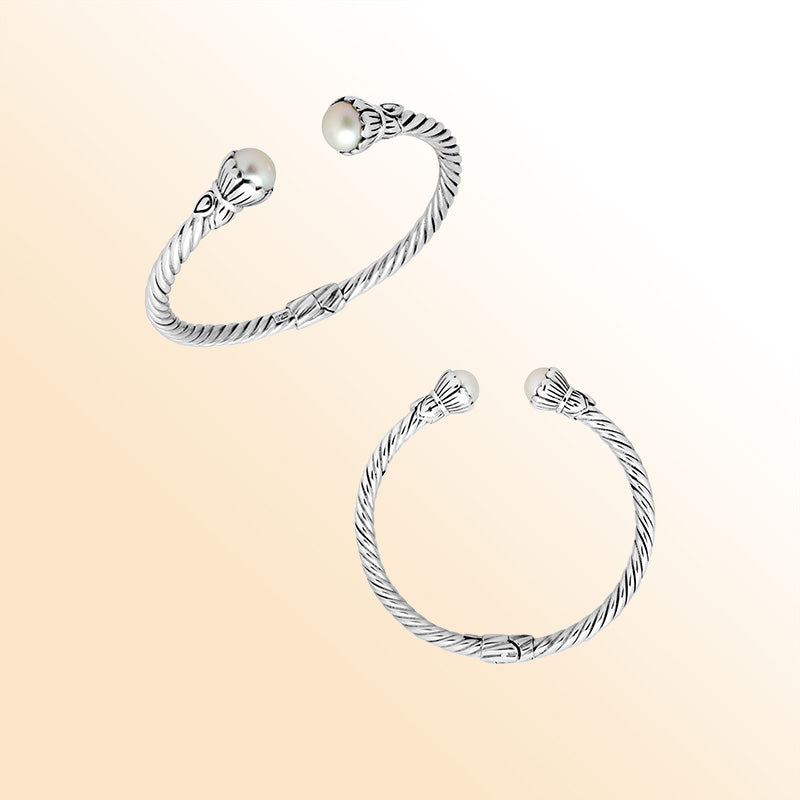 Handcrafted sterling silver cable cuff bracelet featuring smooth Mabe pearl end caps, sculpted detailing, and a secure hinge lock for timeless everyday elegance.