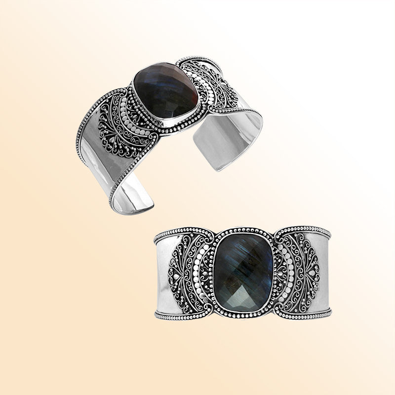 Sterling silver Bali engraved wide cuff bracelet featuring a luminous labradorite center stone with polished–oxidized detailing, designed for expressive and elegant statement wear.