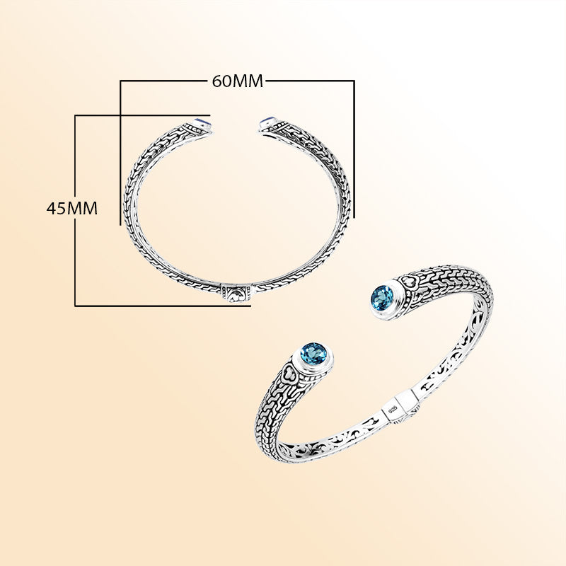 Sterling silver Bali engraved hinge cuff bracelet featuring vibrant blue topaz quartz stones and polished–oxidized detailing, designed for women who enjoy elegant artisan-crafted jewelry.