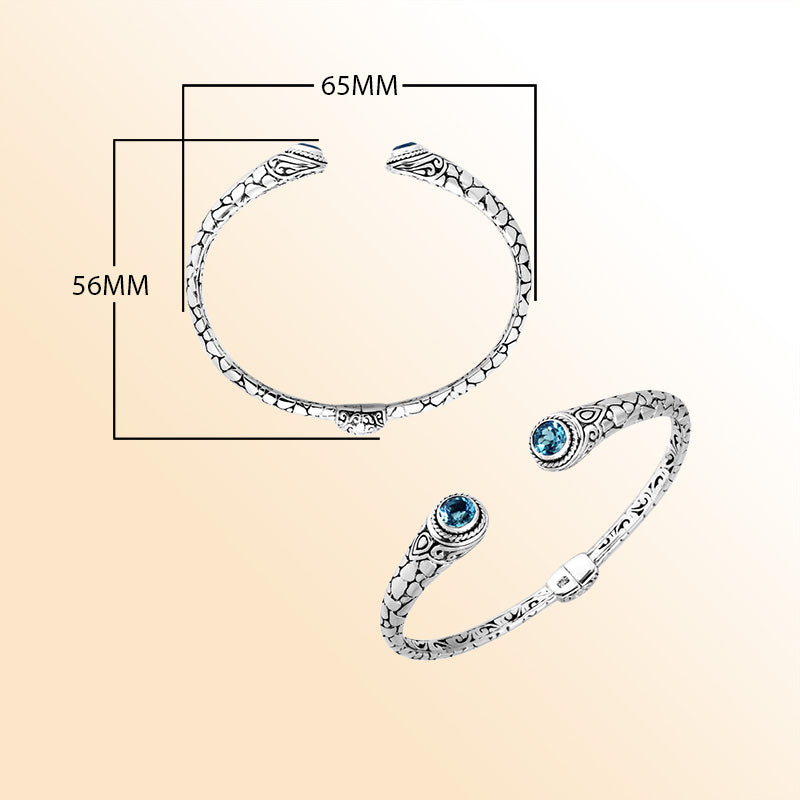 Sterling silver Bali hinge cuff bracelet featuring radiant blue topaz quartz ends and polished–oxidized engravings, designed for individuals who appreciate expressive, artistic, handcrafted jewelry.