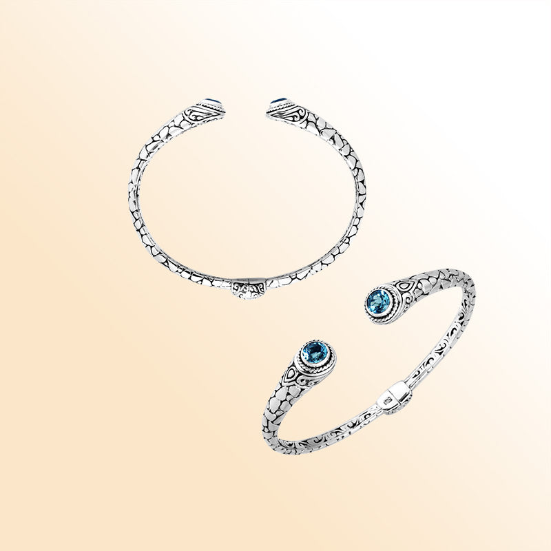 Sterling silver Bali hinge cuff bracelet featuring radiant blue topaz quartz ends and polished–oxidized engravings, designed for individuals who appreciate expressive, artistic, handcrafted jewelry.