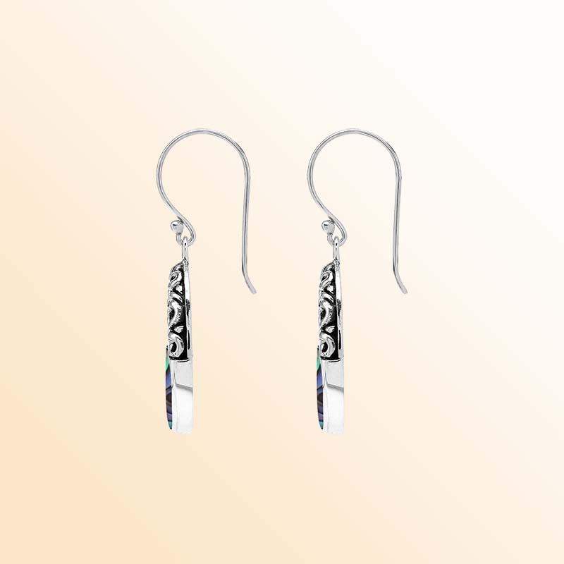 Handcrafted sterling silver dangle earrings with vibrant Abalone Shell inlay, elegant oval openings, sculpted scrollwork, rich oxidized accents, and graceful French ear wires.