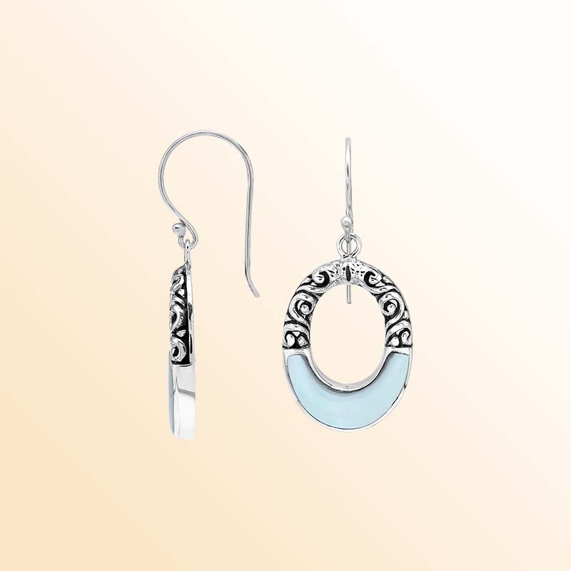 Handcrafted sterling silver dangle earrings showcasing luminous Mother Of Pearl inlays, graceful oval openings, ornate scroll motifs, oxidized accents, polished edges, and elegant French ear wires.