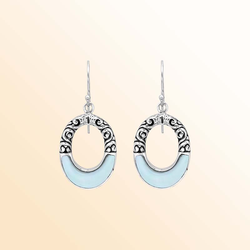 Handcrafted sterling silver dangle earrings showcasing luminous Mother Of Pearl inlays, graceful oval openings, ornate scroll motifs, oxidized accents, polished edges, and elegant French ear wires.
