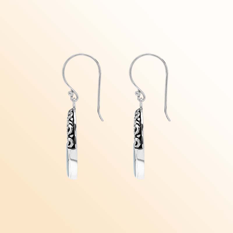 Handcrafted sterling silver dangle earrings showcasing luminous Mother Of Pearl inlays, graceful oval openings, ornate scroll motifs, oxidized accents, polished edges, and elegant French ear wires.