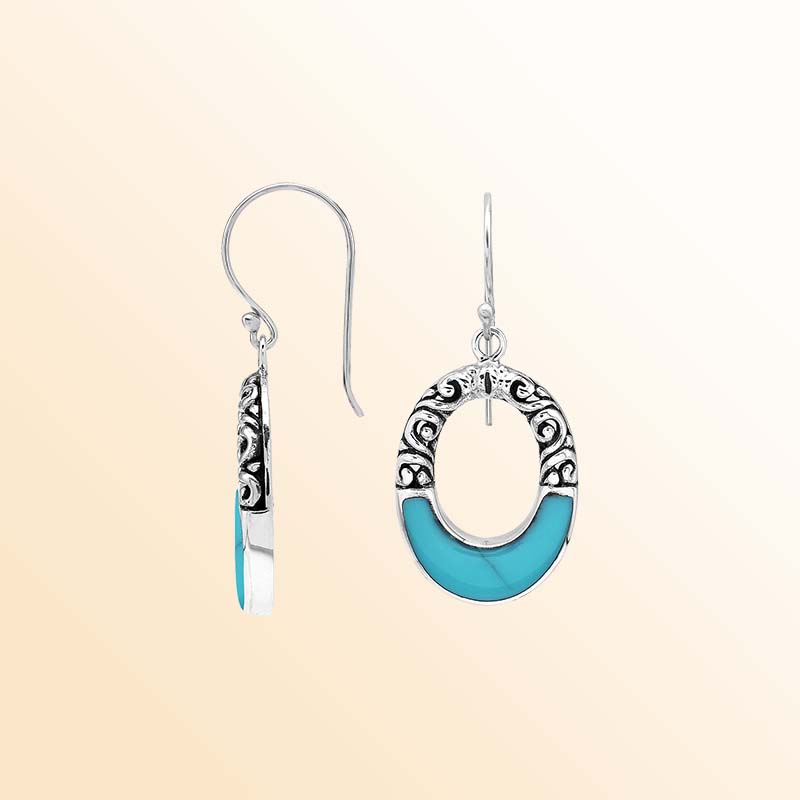 Handcrafted sterling silver dangle earrings showcasing vivid Turquoise Shell inlays, graceful oval openings, ornamental scrollwork, contrasting oxidized accents, polished edges, and elegant French ear wires.