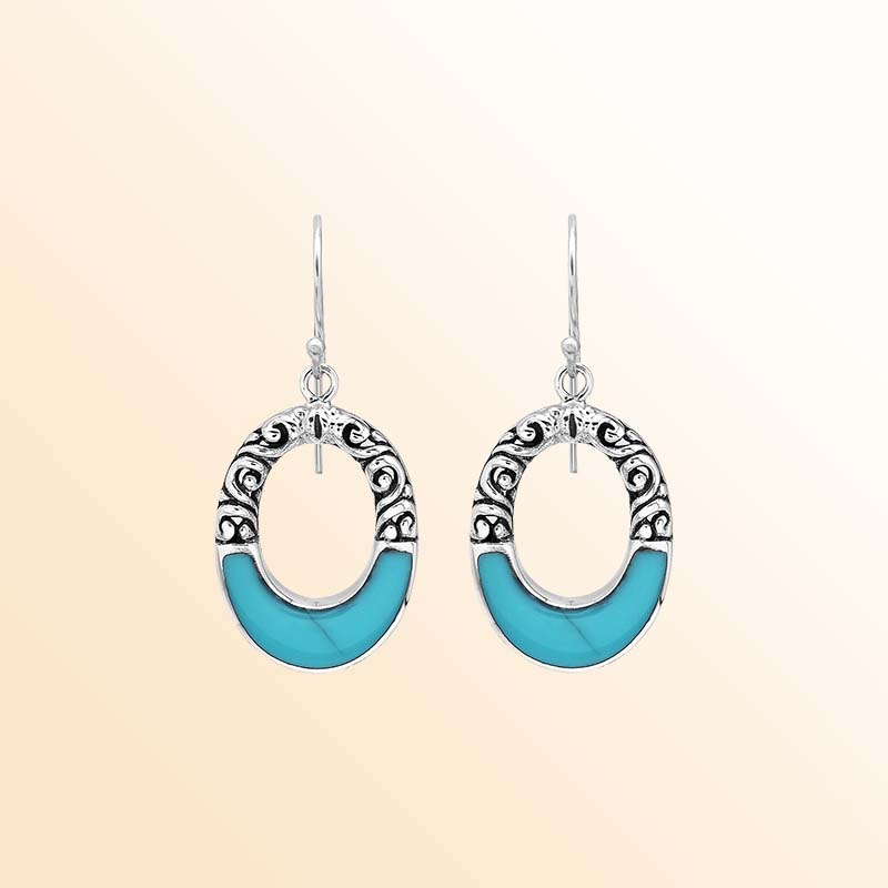 Handcrafted sterling silver dangle earrings showcasing vivid Turquoise Shell inlays, graceful oval openings, ornamental scrollwork, contrasting oxidized accents, polished edges, and elegant French ear wires.
