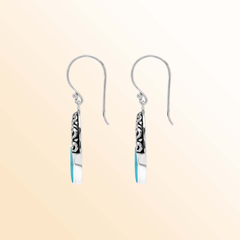 Handcrafted sterling silver dangle earrings showcasing vivid Turquoise Shell inlays, graceful oval openings, ornamental scrollwork, contrasting oxidized accents, polished edges, and elegant French ear wires.