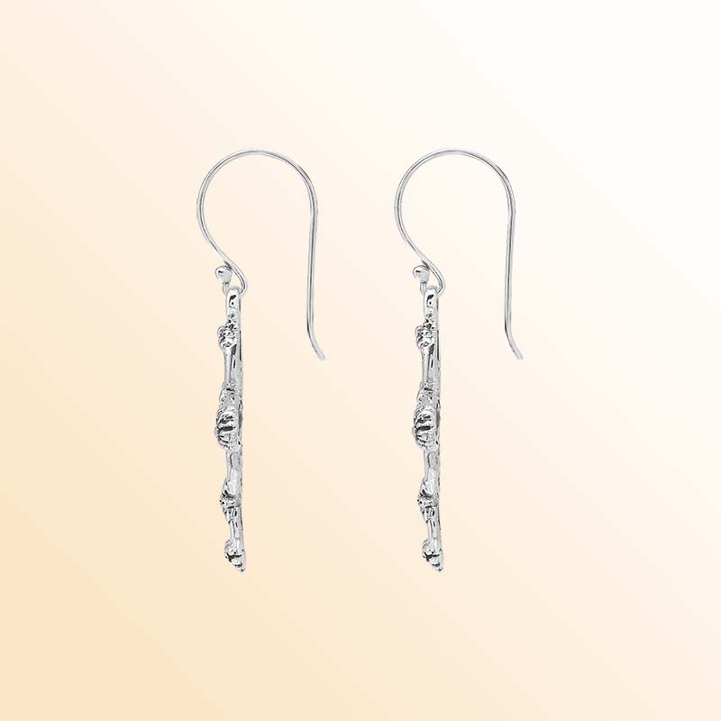 Handcrafted sterling silver floral cross earrings with delicate sculpted blossoms, airy oval openings, luminous polished highlights, oxidized depth, and graceful French ear wires.