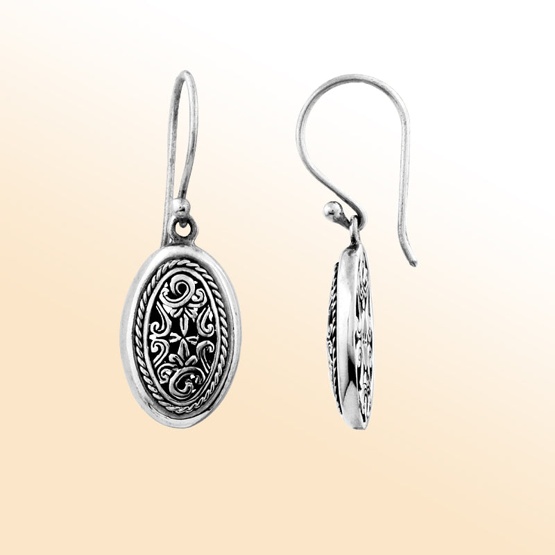 Elegant sterling silver oval earrings with intricate filigree scrollwork and oxidized artisan detailing.