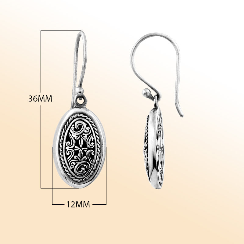 Elegant sterling silver oval earrings with intricate filigree scrollwork and oxidized artisan detailing.